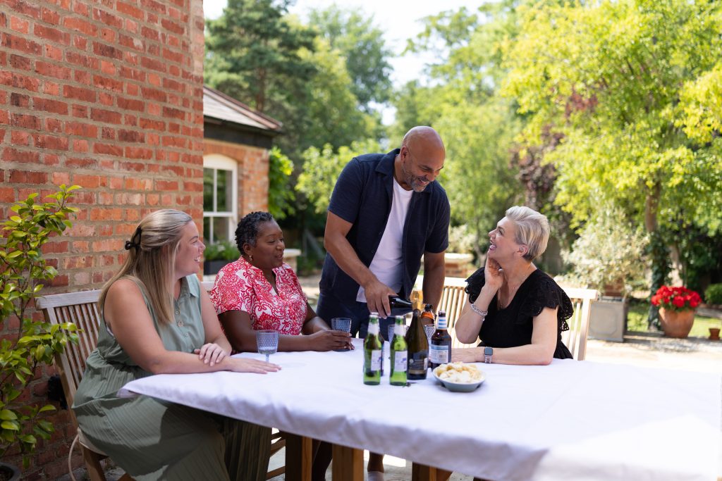 4 people outside around a table with drinks