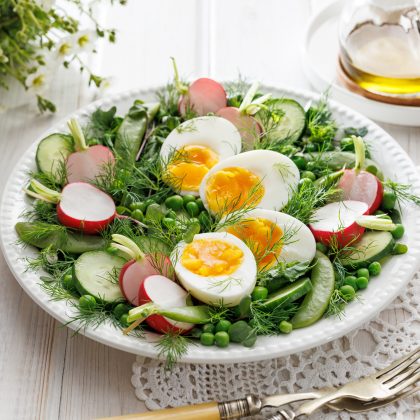 Spring salad with eggs and vegetables on a white plate, close-up. Easter food concept Protein East Meal