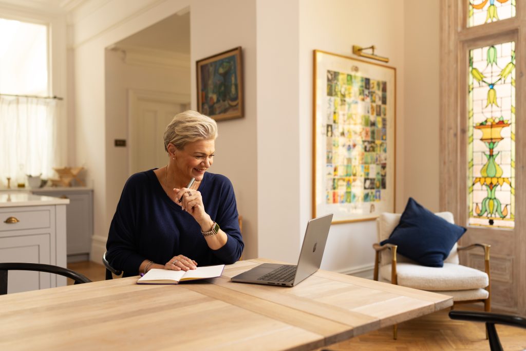 women with laptop on dining table.