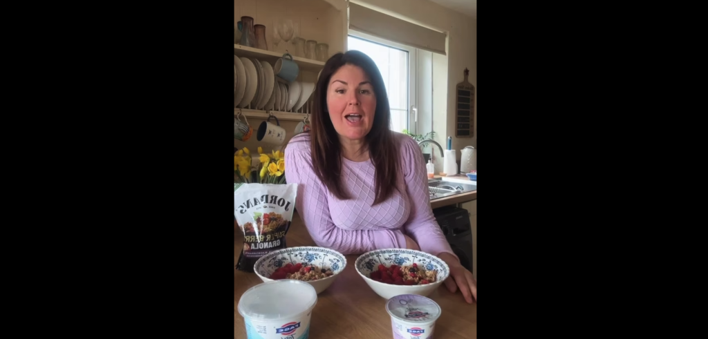Women sitting in kitchen with bowls of cereal and yogurt