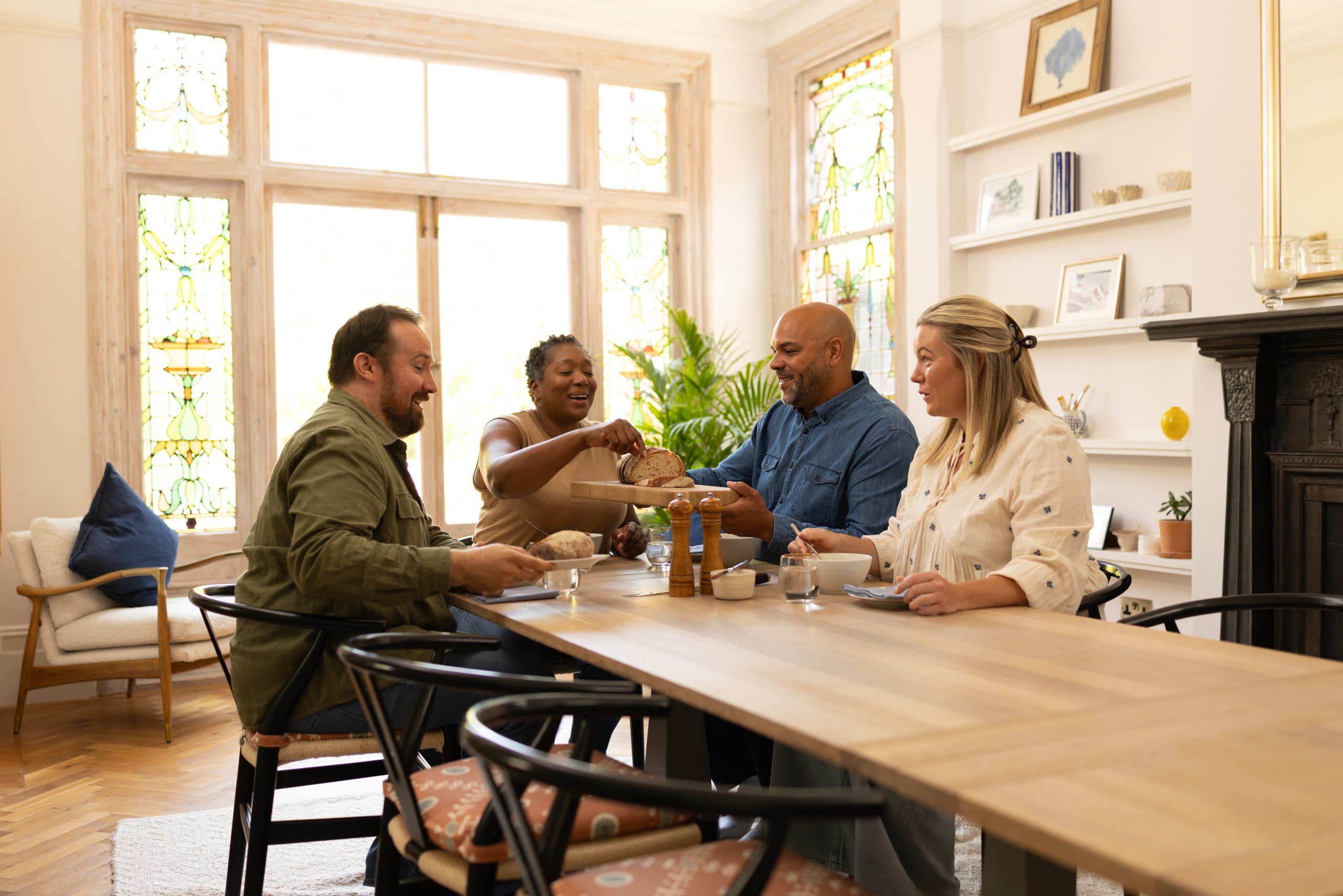 2 couples laughing around a dining table