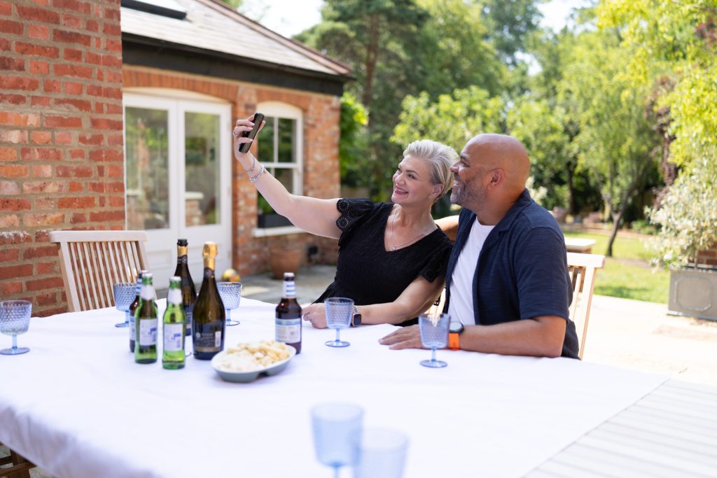 Couple taking picture outside around table