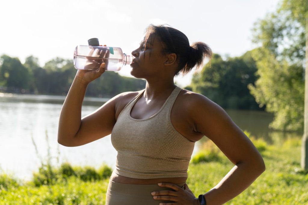 Woman drinking water by lake